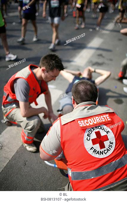 Photo essay. Paris Marathon, April 2007. First aid attendants from the French Red Cross with an injured person