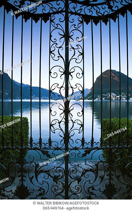 Switzerland, Ticino, Lake Lugano, Lugano, Parco Civico gate view of Monte San Salvador, dawn
