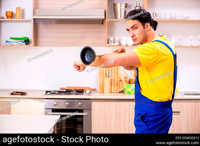 Young male contractor repairing tap at home