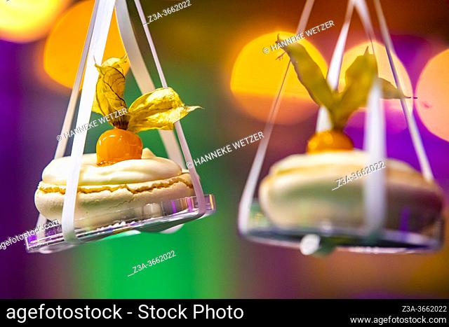 Merengues hanging from a lighted design cloud construction as a decor for the presentation of desserts, Strijp-S, Eindhoven, The Netherlands, Europe