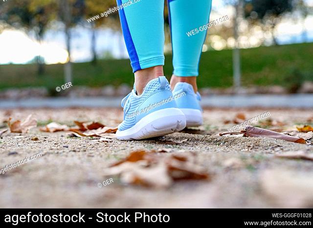 Young sportswoman walking in park