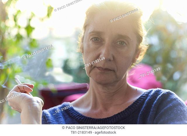 Woman smoking quietly in the garden, Javea, Alicante, Valencia, Spain