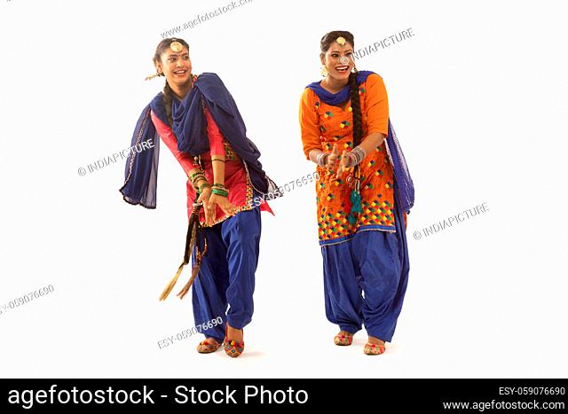 Two Giddha Dancers performing a dance step together