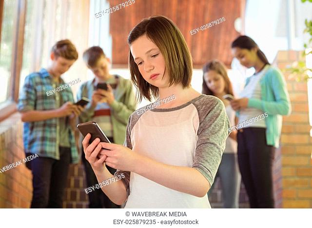 Schoolgirl using mobile phone in corridor