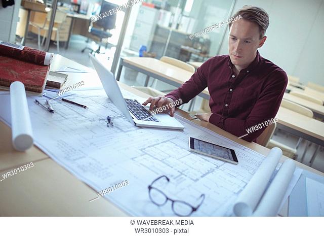 Architect using laptop at table