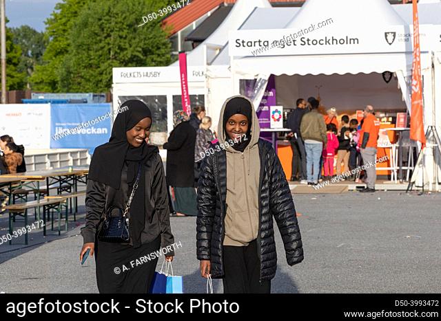 Stockholm, Sweden Two young Muslim women walking at the Jarvaveckan political rally in the Spanga suburb
