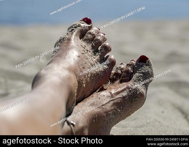 30 May 2020, Schleswig-Holstein, Timmendorfer Strand: A woman is sunbathing at the Timmendorfer Strand at the Baltic Sea