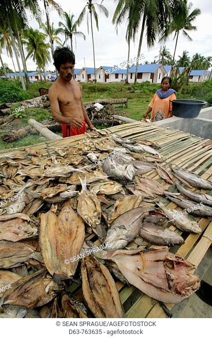 Zaman, a fisherman, smoking fish by CRS housing project at Seunebok Tuengoh relocation site, Meulaboh, Aceh, two years after the Tsunami, Indonesia