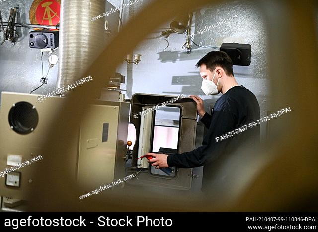 26 March 2021, Berlin: Employee Thore Horch checks the digital and analog projectors in the projection room of Kino International on Karl-Marx-Allee in Mitte
