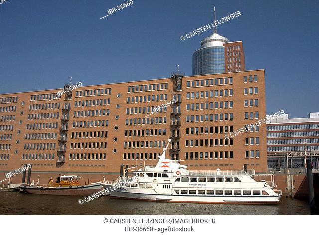 A trip boat is lying in front of the Hanseatic Trade Center HTC at Kehrwiederspitze at Hambug Hafencity Germany