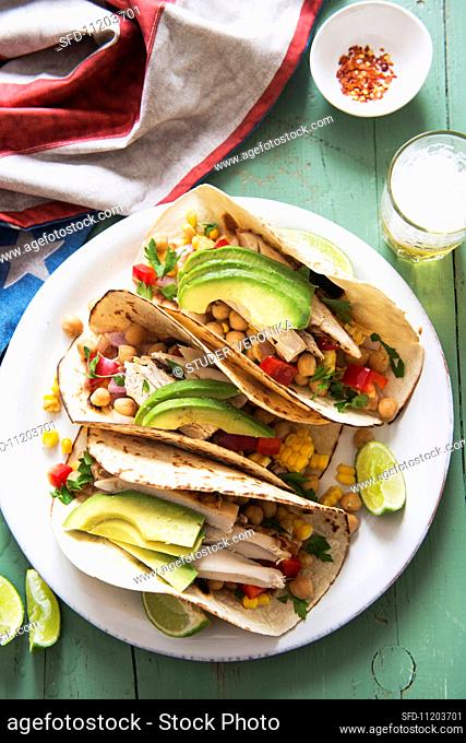 Tacos filled with chicken, chickpeas, sweetcorn and avocado