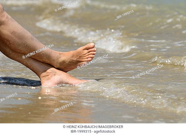 Sea water flowing around the feet of a woman, Roseto degli Abruzzi, Abruzzo region, Italy, Europe
