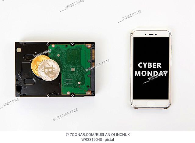 Bitcoin coins on the HDD and phone with Cyber Monday sign