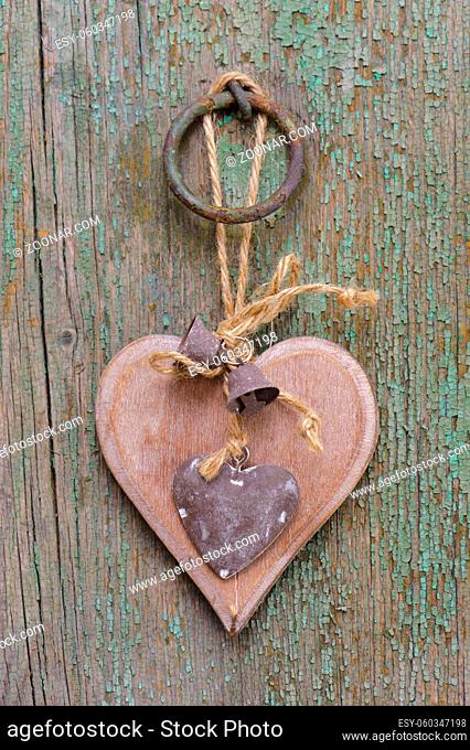 carved wooden heart hanging on plank as symbol for love and romance