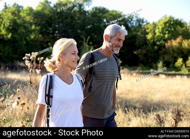 Smiling mature couple hiking in forest