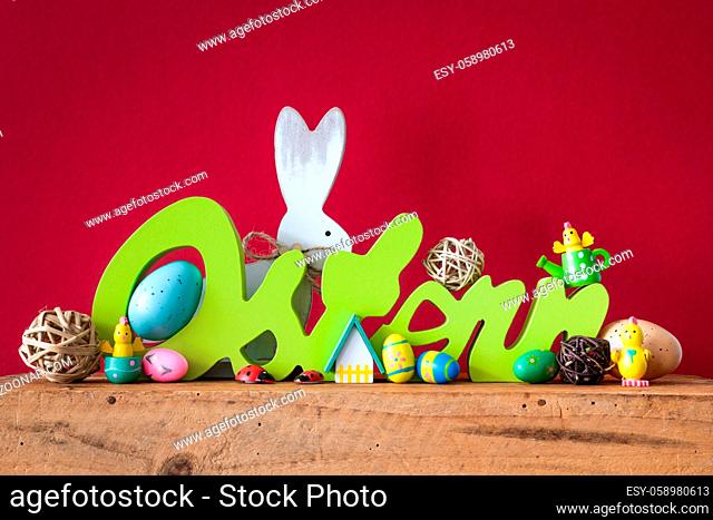 The word Easter in german language with easter bunny eggs and chicks