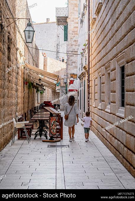 Mother walks with her son through the alleys of the old town of Dubrovnik, Dalmatia, Croatia