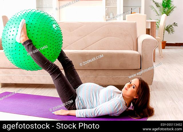 Young pregnant woman doing sport exercises at home