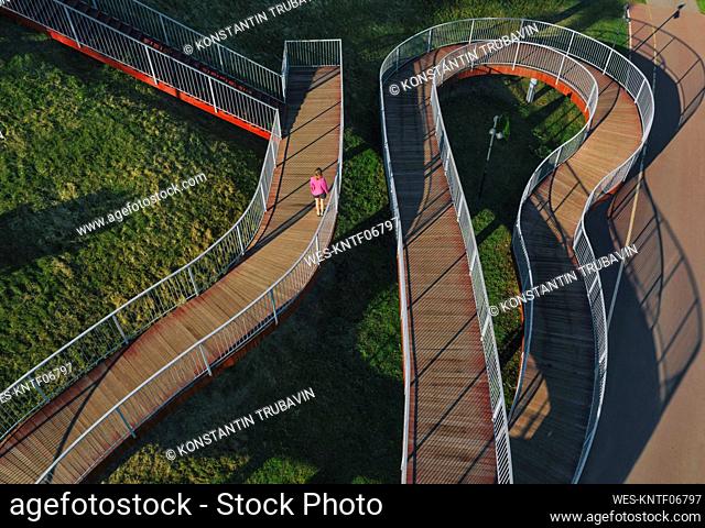 Russia, Aerial view of woman standing on winding boardwalk