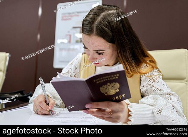 RUSSIA, KHERSON REGION - 11 de diciembre de 2023: Un empleado trabaja en un centro de servicios públicos Moi Dokumenty en la ciudad de Genichesk