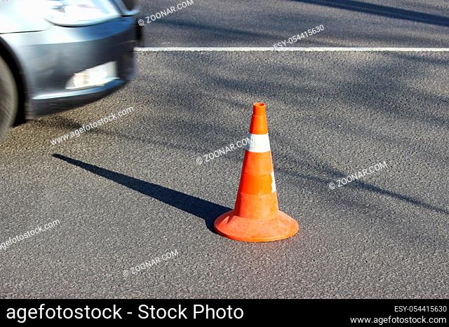 plastic signaling traffic cone encloses a place in the parking lot for trucks