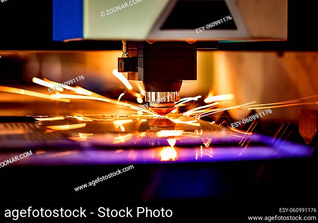 CNC Laser cutting of metal, modern industrial technology. Small depth of field. Warning - authentic shooting in challenging conditions