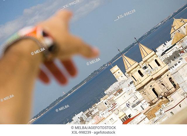 Close-up of a human hand pointing to a church of San Antonio  Cadiz  Andalusia  Spain