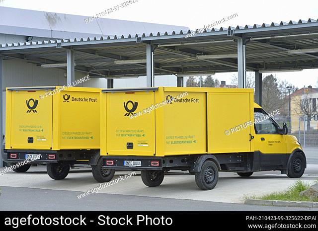 01 April 2021, Saxony, Leipzig: ""This vehicle runs on electric power"". Several of Deutsche Post's StreetScooter electric transporters stand at charging...