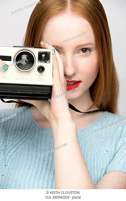 Young woman with polaroid camera