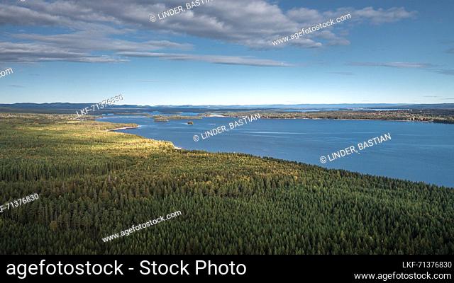 Forest and lakeshore at Lake Siljan from above with blue sky in Dalarna, Sweden