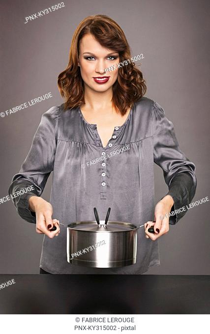 Young woman holding stew pot