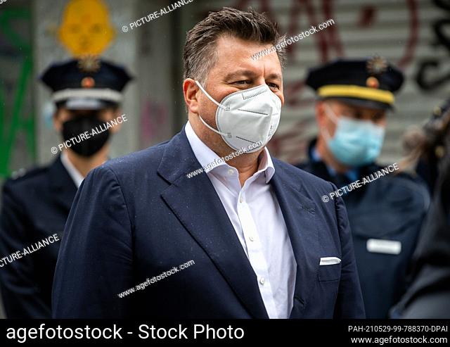 28 May 2021, Berlin: Andreas Geisel (SPD), Senator of the Interior of Berlin, stands in front of police officers during a press event in the Regenbogenkiez