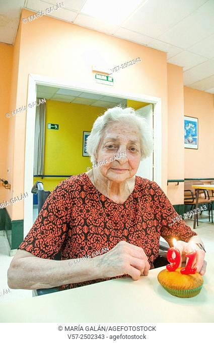 Old woman in a nursing home, celebrating her ninety first birthday, smiling and looking at the camera