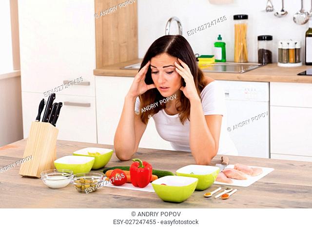 Young Unhappy Woman In Kitchen Near Different Ingredient