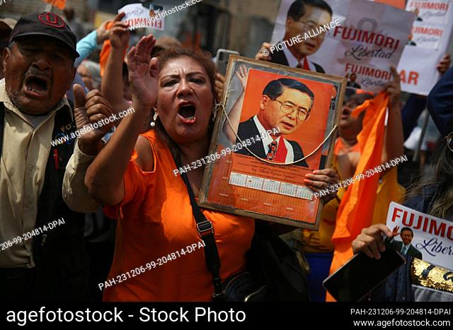 06 December 2023, Peru, Lima: Demonstrators hold up pictures and an old calendar showing a portrait of former Peruvian President Fujimori