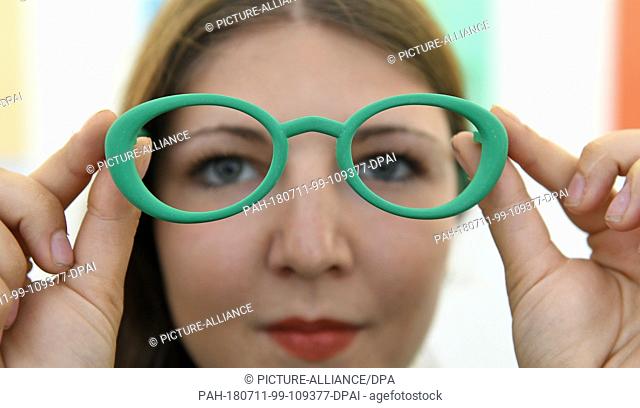 11 July 2018, Germany, Halle/Saale: The student Sophia Reissenweber shows her work 'Resus' with spectacle frames made of recycled materials during a pre-tour of...