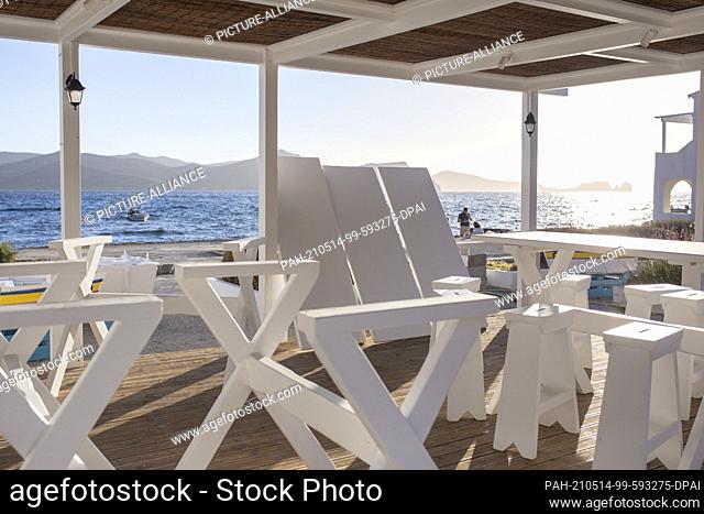 13 May 2021, Greece, Milos: Freshly painted chairs and tables stand on a terrace. On 14.05.2021, the tourism season will officially begin in Greece -...