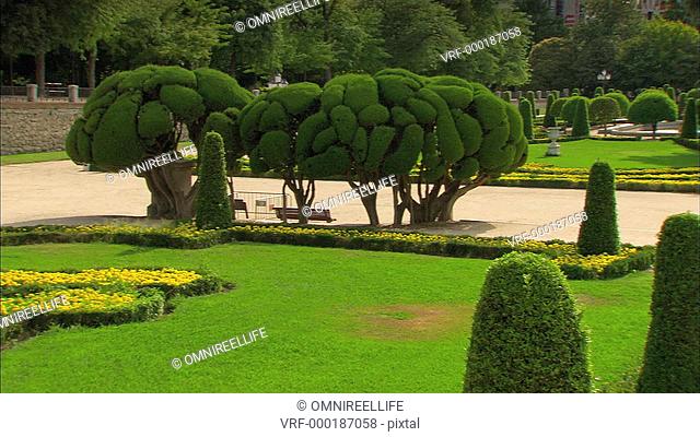 El Retiro Park topiary designs with monument and Museo del Prado behind