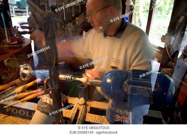 Amberley Working Museum. The West Sussex Woodturners with a man working at Machinery demonstrating traditional wood-working tools and skills