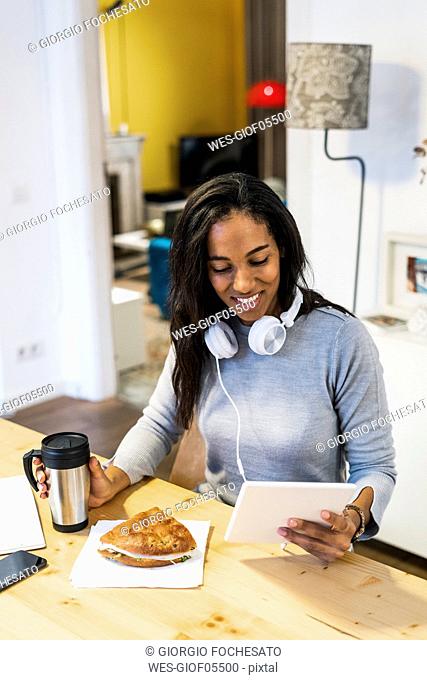 Smiling woman using tablet at table