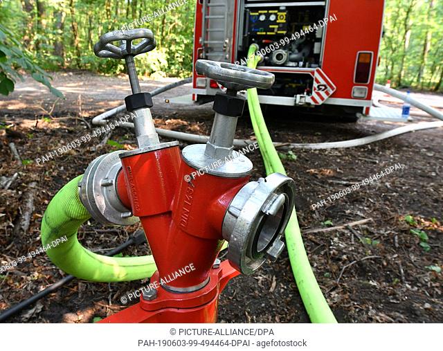 03 June 2019, Berlin: A fire truck taps water from a hydrant in Grunewald. According to the fire department, about 40000 square meters of forest floor burned