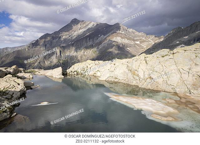Small icy lake with Espadas peak in the background. Posets-Maladeta Natural Park. Aragon. Spain