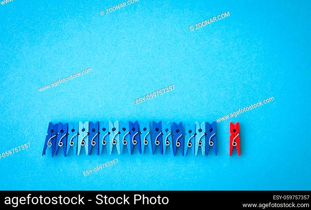 Kleine bunte Waescheklammern auf blauem Hintergrund