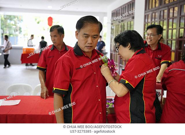Pinning flower for VIP during Sarawak Chai's Clan Association Chinese New Year dinner party in Kuching, Malaysia