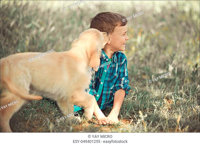 Cute handsome boy teen with blue eyes playing outdoor amazing white pink labrador retriever puppy enjoying summer sunny day vacation weekend with full happyness