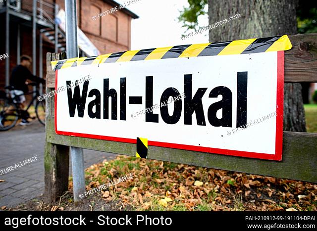 12 September 2021, Lower Saxony, Delmenhorst: A sign reading ""Wahl-Lokal"" (polling station) hangs on the driveway to a primary school that houses a polling...