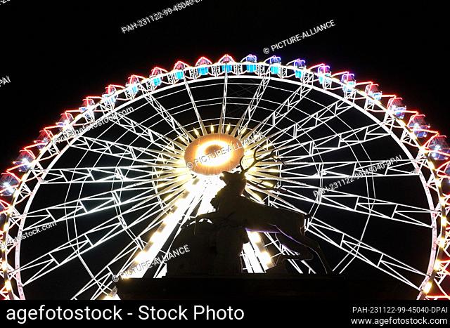 21 November 2023, Baden-Württemberg, Stuttgart: A colorful illuminated Ferris wheel stands on the Schlossplatz. Photo: Bernd Weißbrod/dpa