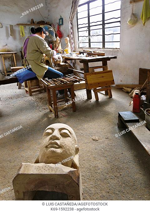 Worker sculpting and wood carving at his studio. Suzhou. China