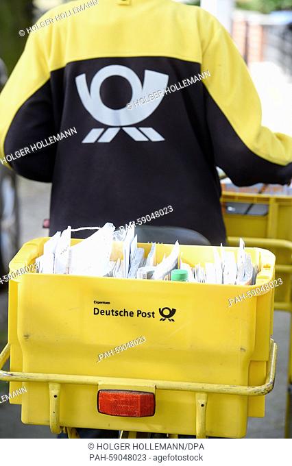 A mail carrier delivers mail in Langenhagen, Germany, 09 June 2015. Deutsche Post employees in various states have begun an open-ended strike