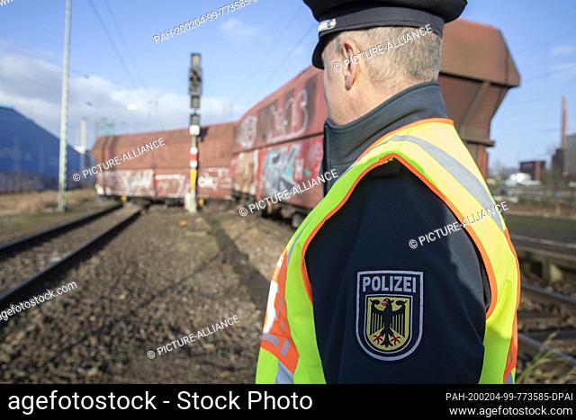 04 February 2020, Bremen: A federal police officer is standing in front of a derailed freight train. One of the 38 empty wagons of the train on its way from...